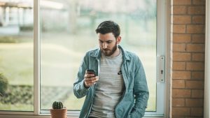 man browsing social media on cell phone